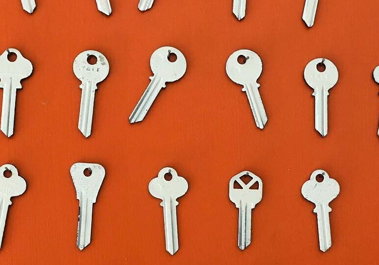 Silver keys arranged on an orange background.