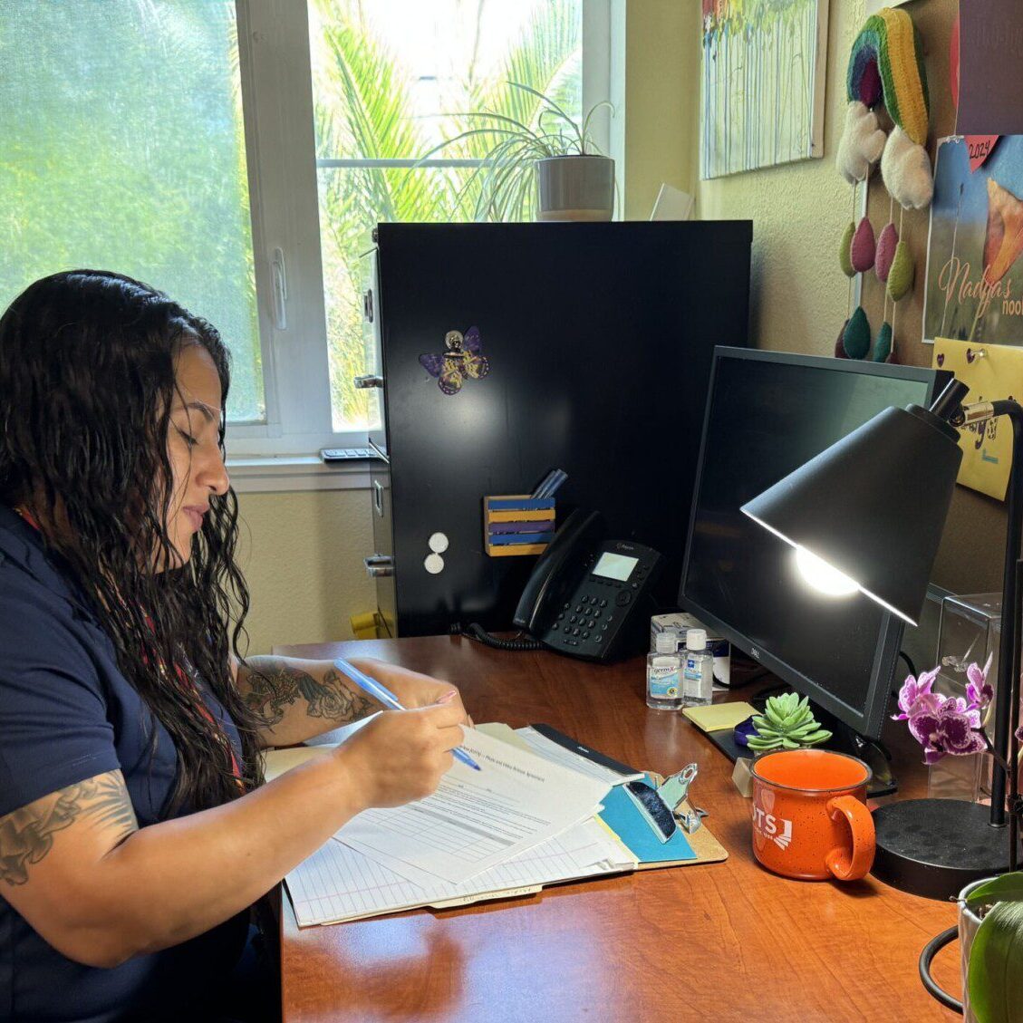Person working at a desk with documents.
