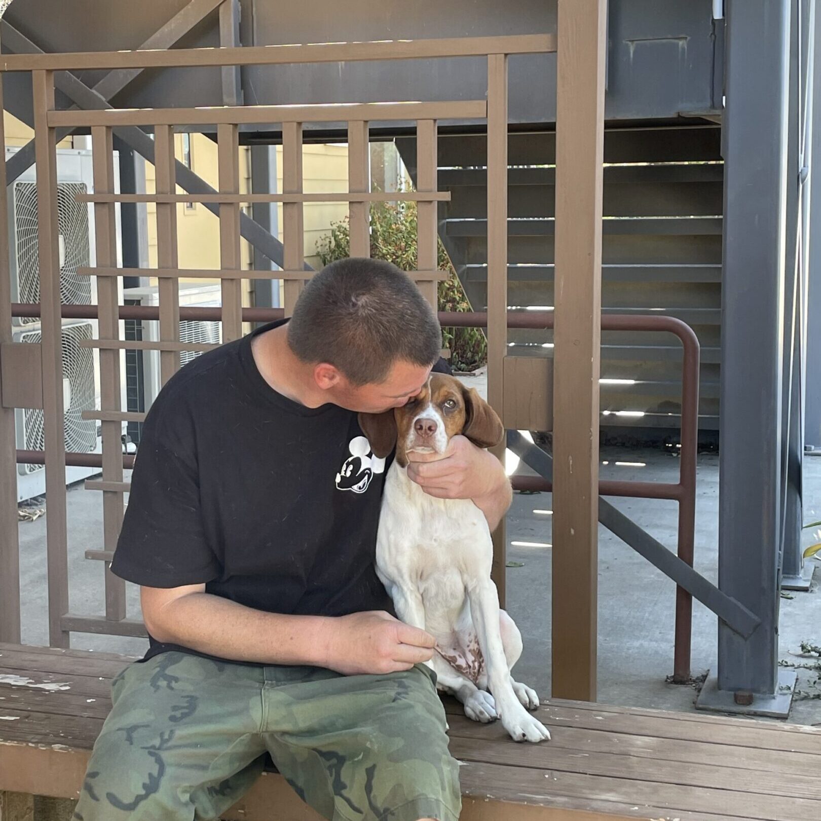 Man sitting with a dog outside.
