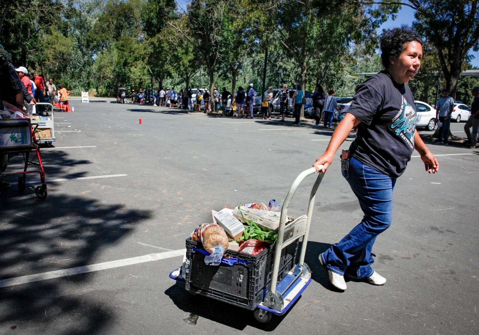 Karina Toledo carts a crate of food that she received from the Redwood Empire Food Bank on Thursday, July 16, 2026. (Photo by CRISSY PASCUAL/PETALUMA VOICE ©2026)